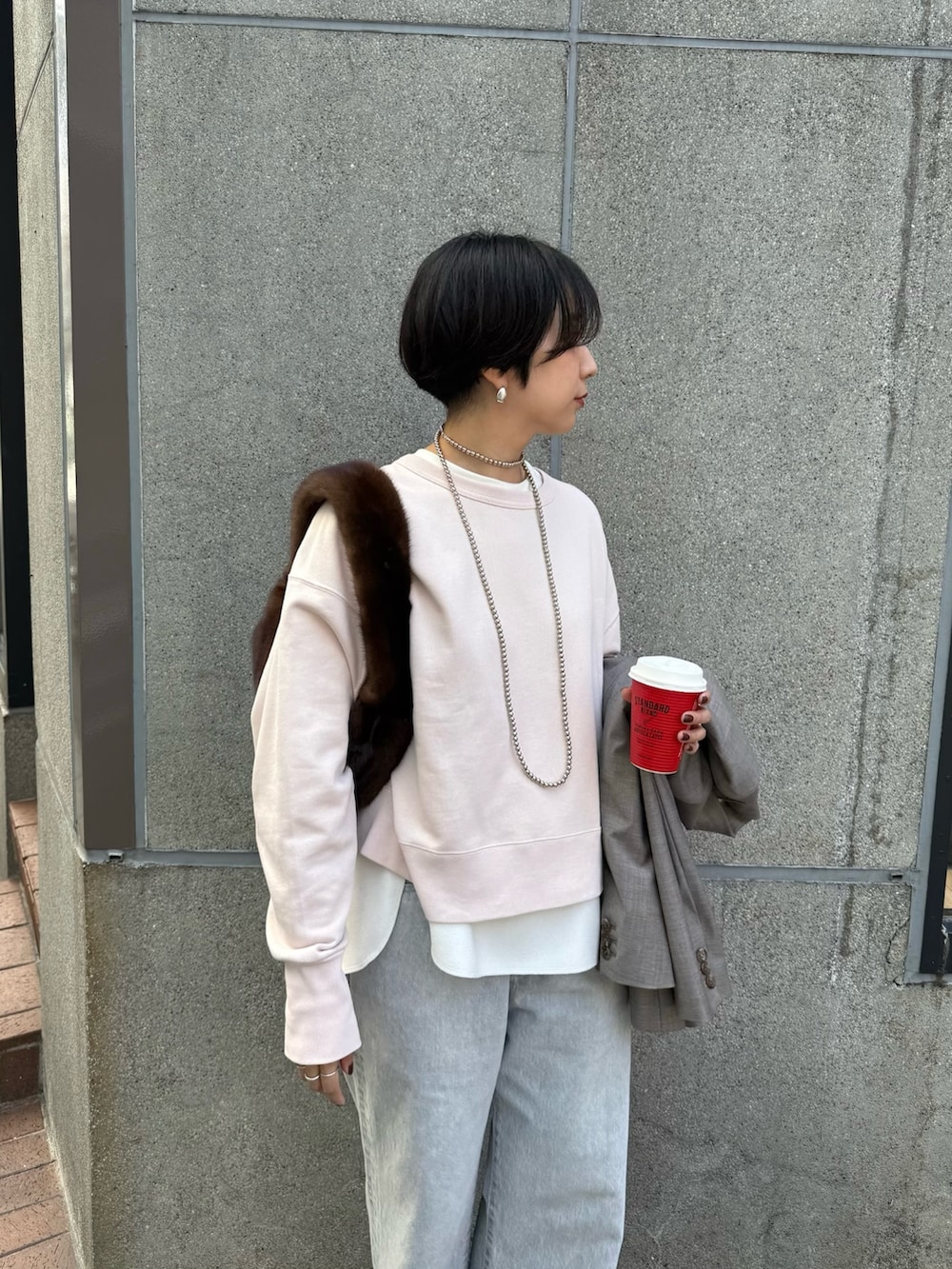 グレー系のテーラードジャケット、ホワイト系のシャツ/ブラウス、グレー系のデニムパンツを着用したレディースの秋コーディネートの6枚目の写真