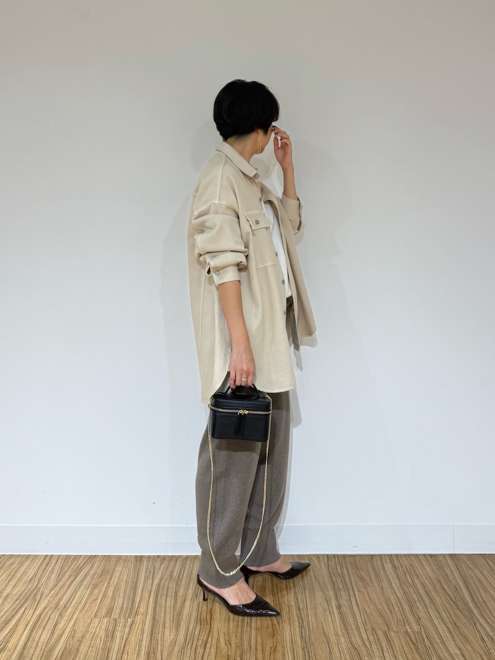 ホワイト系のシャツ/ブラウス、ベージュ系のシャツ/ブラウス、ブラック系のショルダーバッグを着用したレディースの秋コーディネートの6枚目の写真