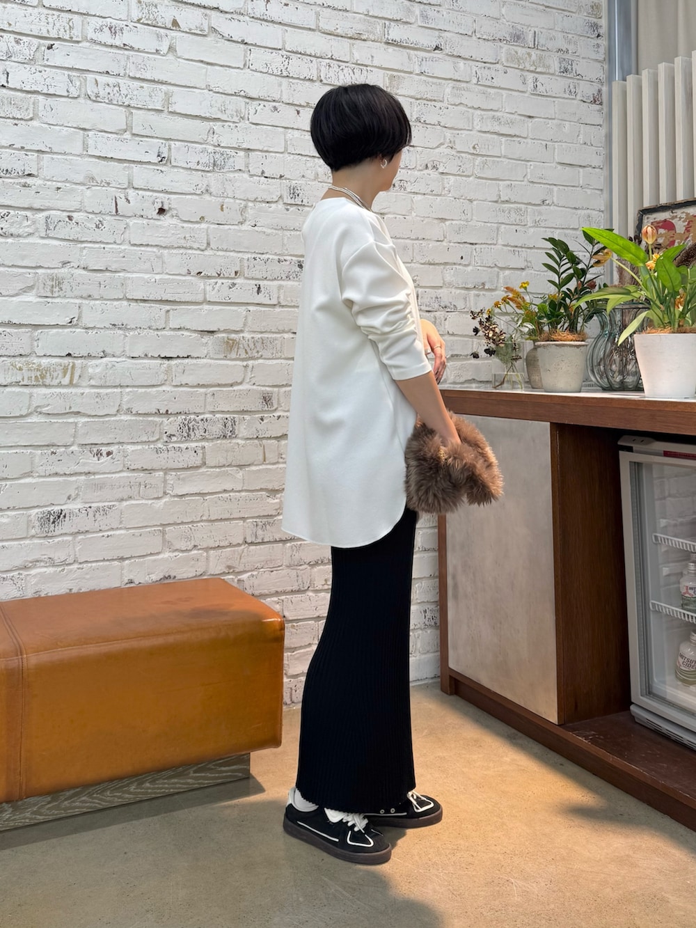 グレー系のチェスターコート、ホワイト系のシャツ/ブラウス、ブラック系のスカートを着用したレディースの秋コーディネートの5枚目の写真