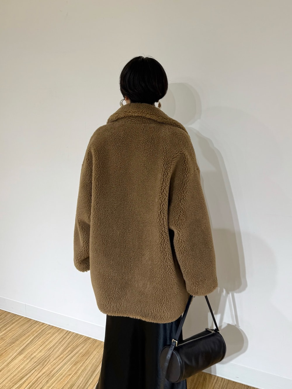 ブラウン系のその他アウター、ブラウン系のニット/セーター、ブラック系のスカートを着用したレディースの秋コーディネートの6枚目の写真