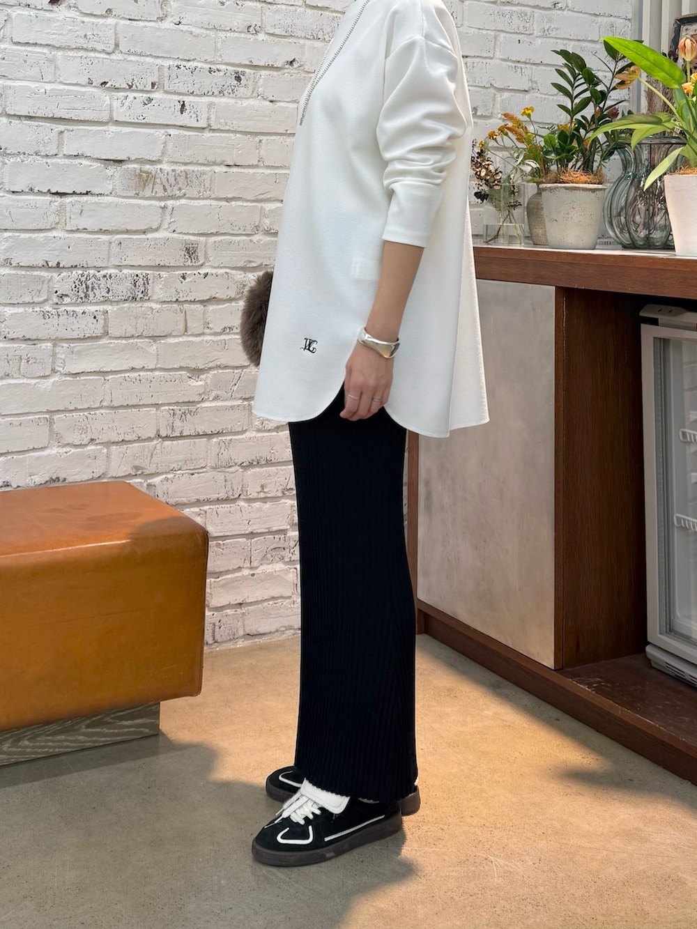 グレー系のチェスターコート、ホワイト系のシャツ/ブラウス、ブラック系のスカートを着用したレディースの秋コーディネートの7枚目の写真