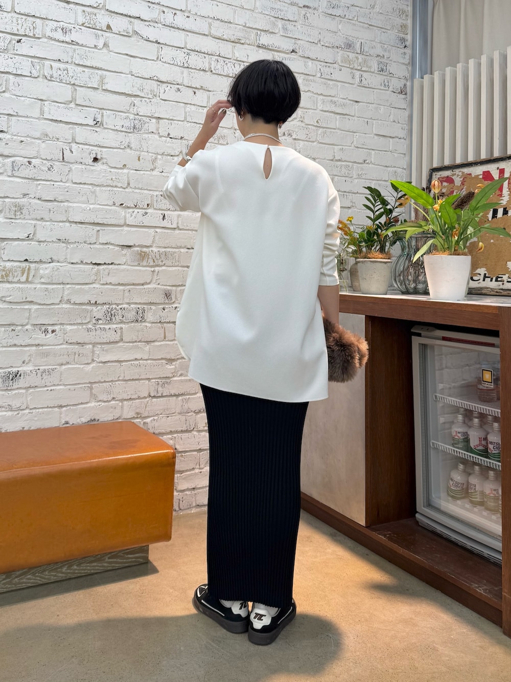 グレー系のチェスターコート、ホワイト系のシャツ/ブラウス、ブラック系のスカートを着用したレディースの秋コーディネートの6枚目の写真