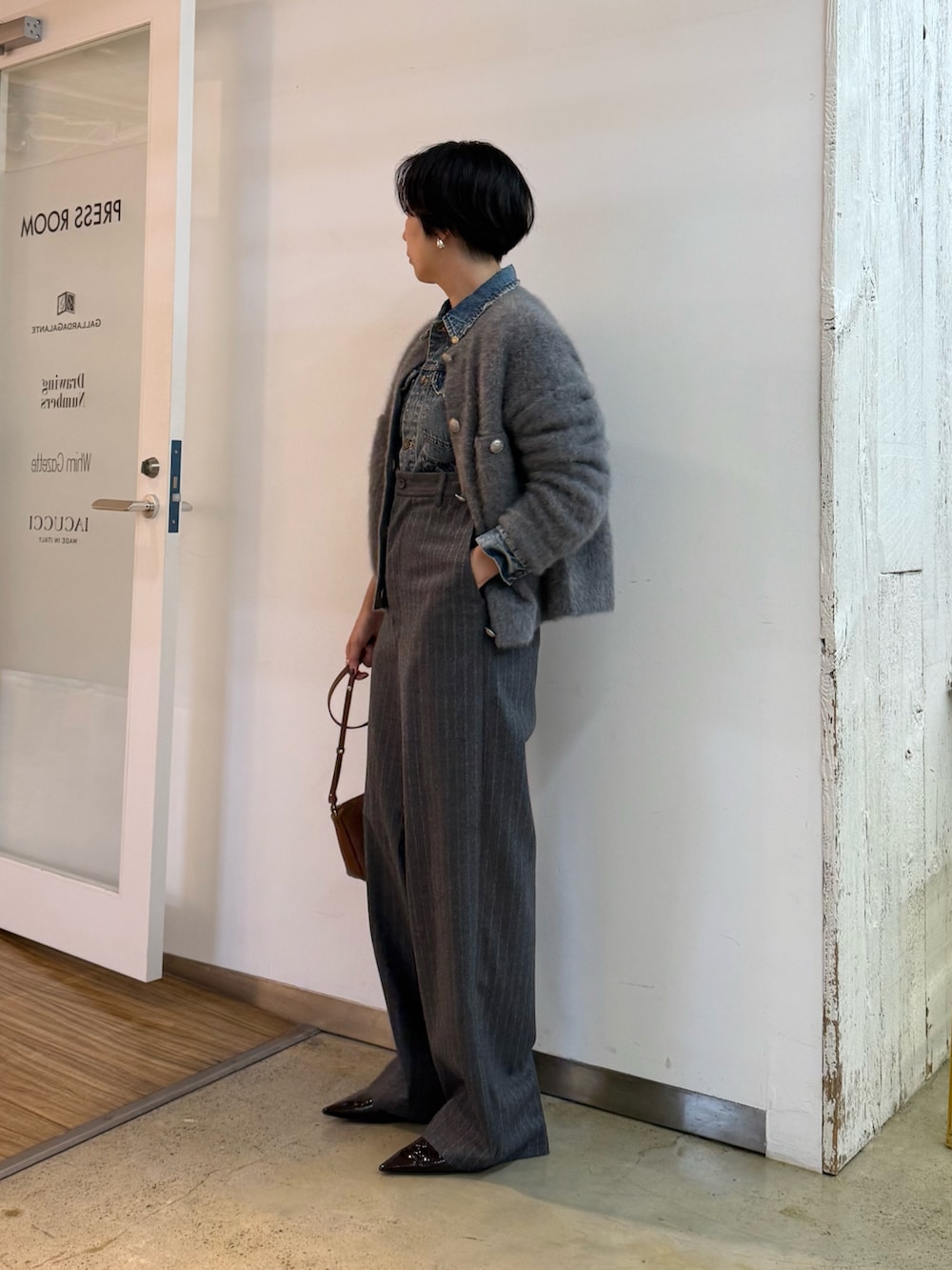 グレー系のカーディガン/ボレロ、ブルー系のデニムジャケット、ブラウン系のパンプスを着用したレディースの秋コーディネートの2枚目の写真