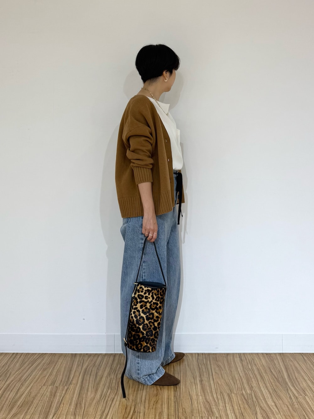 ブルー系のデニムパンツ、イエロー系のショルダーバッグ、ホワイト系のシャツ/ブラウスを着用したレディースの秋コーディネートの2枚目の写真