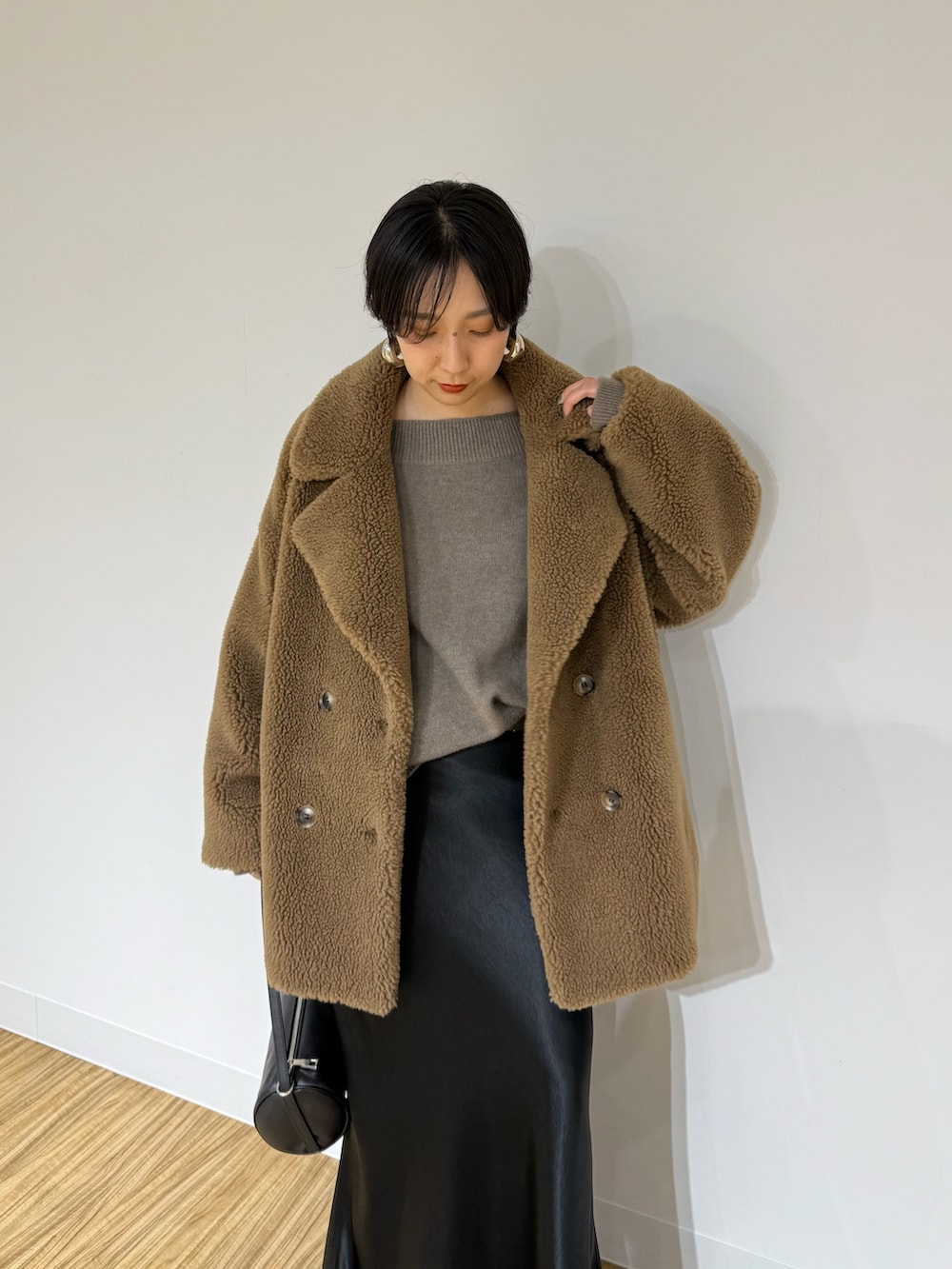 ブラウン系のその他アウター、ブラウン系のニット/セーター、ブラック系のスカートを着用したレディースの秋コーディネートの5枚目の写真