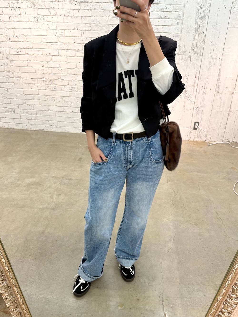 ブラック系のテーラードジャケット、ブルー系のデニムパンツ、ブラック系のスニーカーを着用したレディースの夏コーディネートの7枚目の写真
