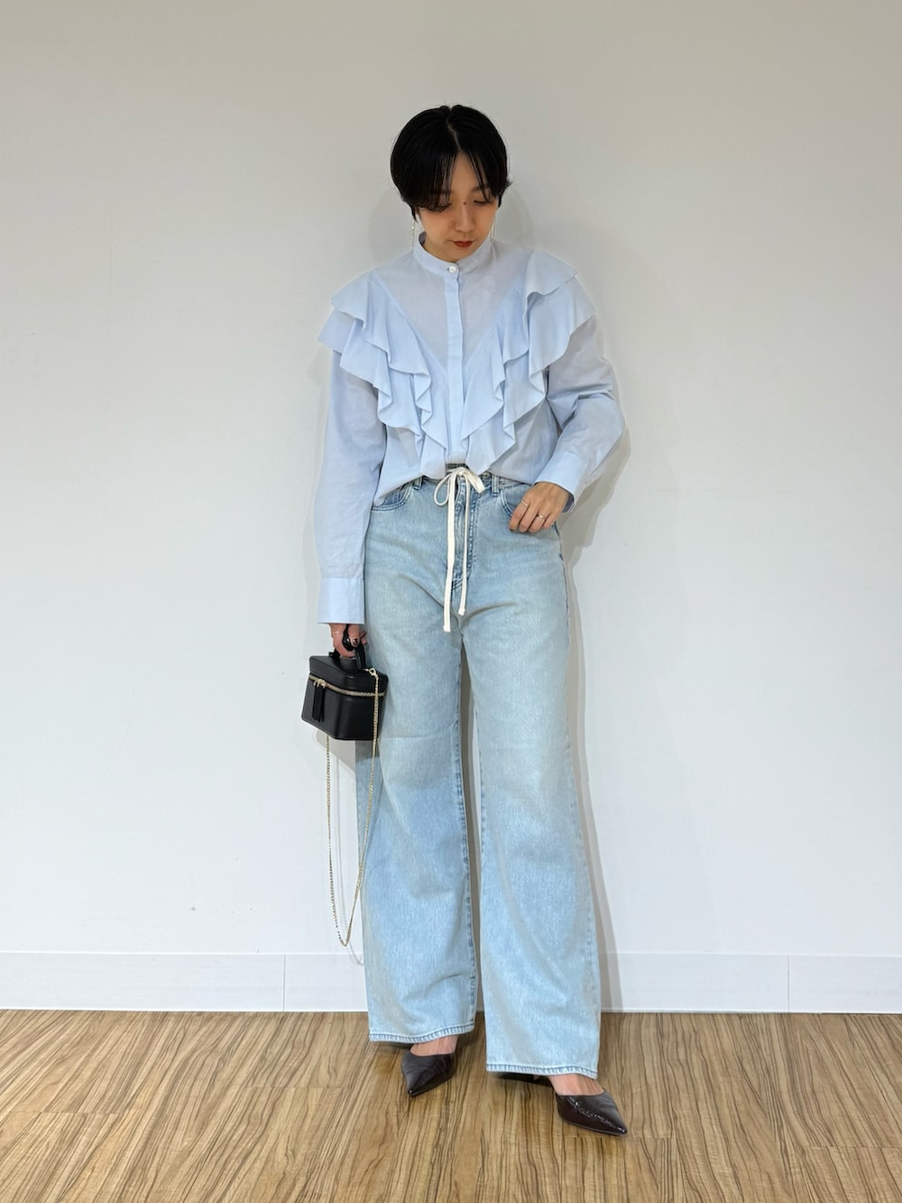 ブルー系のシャツ/ブラウス、ブラウン系のその他アウター、ブルー系のデニムパンツを着用したレディースの秋コーディネートの4枚目の写真