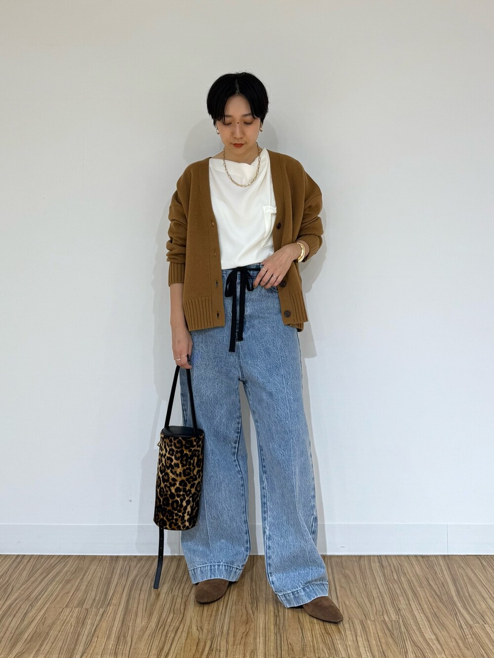 ブルー系のデニムパンツ、イエロー系のショルダーバッグ、ホワイト系のシャツ/ブラウスを着用したレディースの秋コーディネートの6枚目の写真