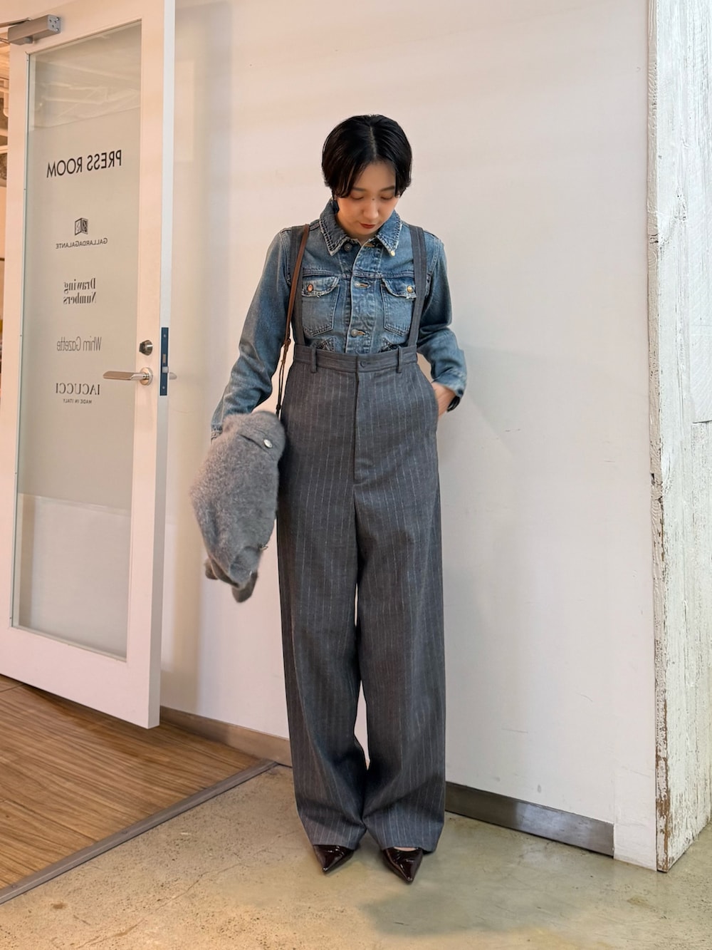 グレー系のカーディガン/ボレロ、ブルー系のデニムジャケット、ブラウン系のパンプスを着用したレディースの秋コーディネートの6枚目の写真