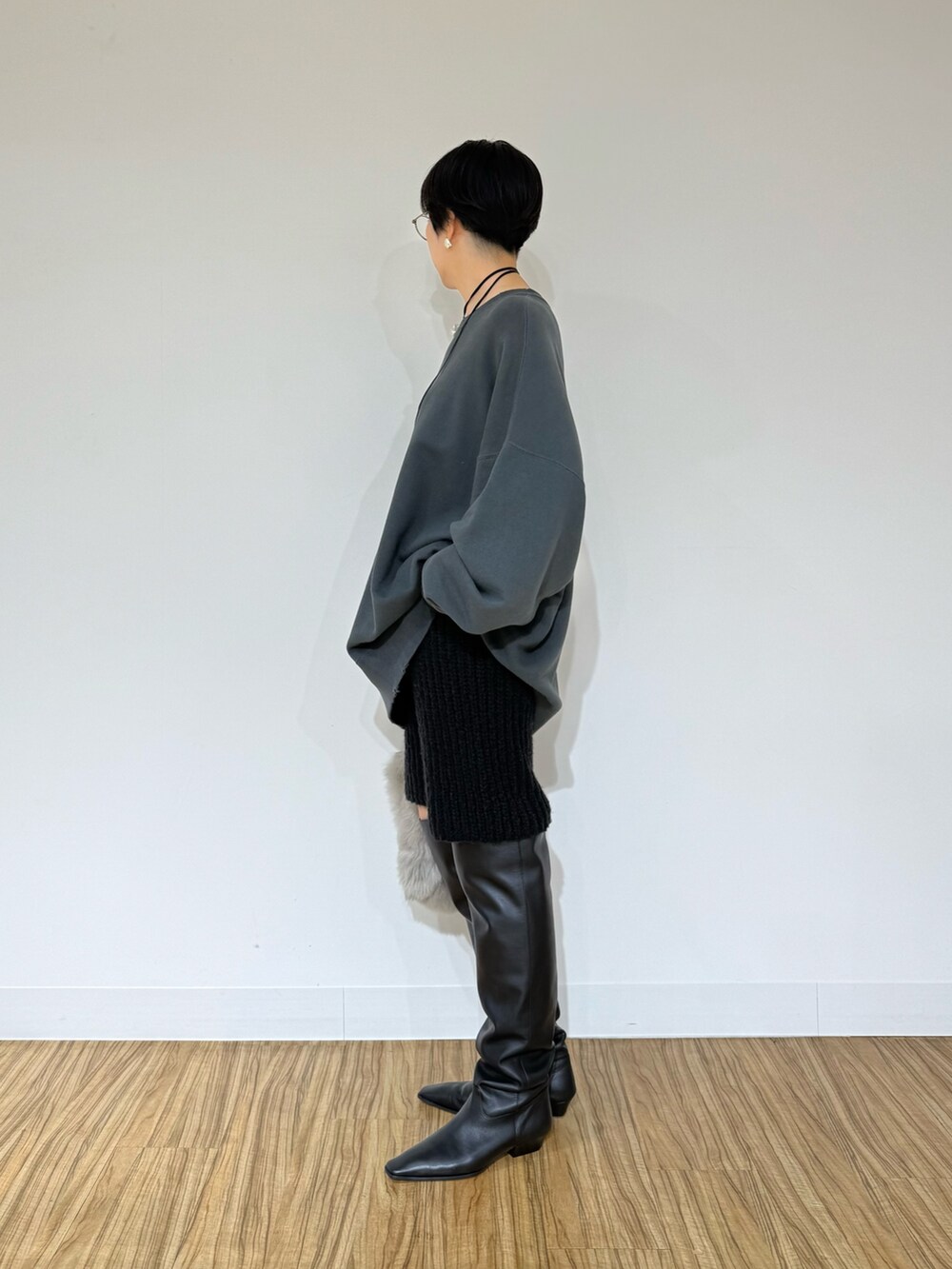 グレー系のスウェット、ブラック系のブーツ、ブラック系のその他パンツを着用したレディースの秋コーディネートの2枚目の写真