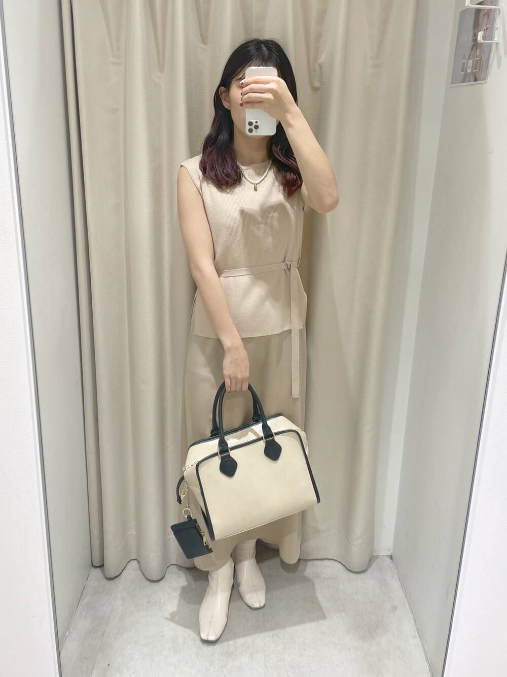 ベージュ系のワンピース、ホワイト系のボストンバッグを着用したレディースの冬コーディネートの2枚目の写真