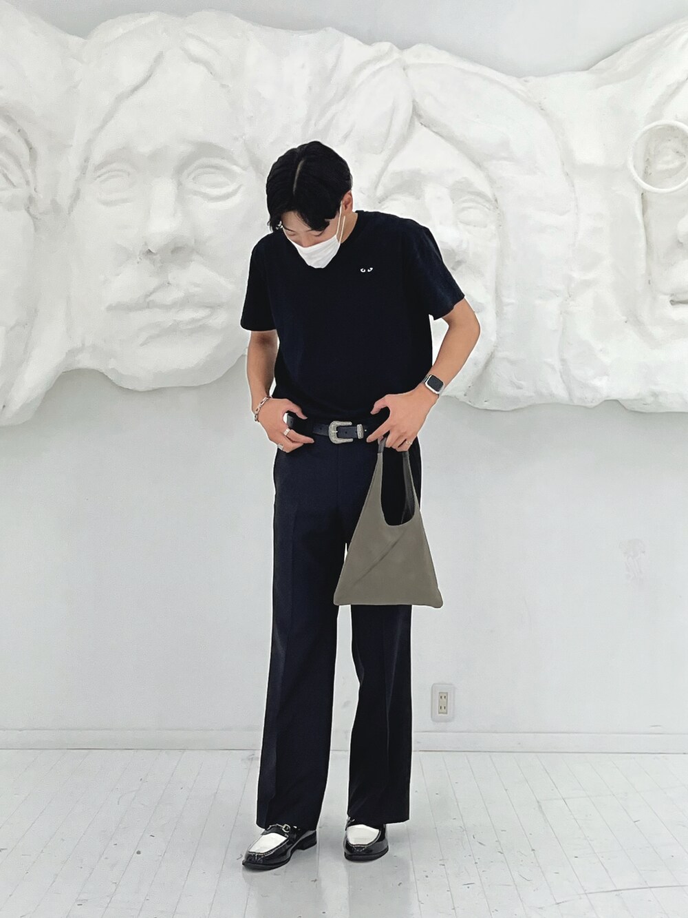 グレー系のバッグ、ブラック系のスラックス、ブラック系のTシャツ/カットソーを着用したメンズの秋コーディネートの2枚目の写真