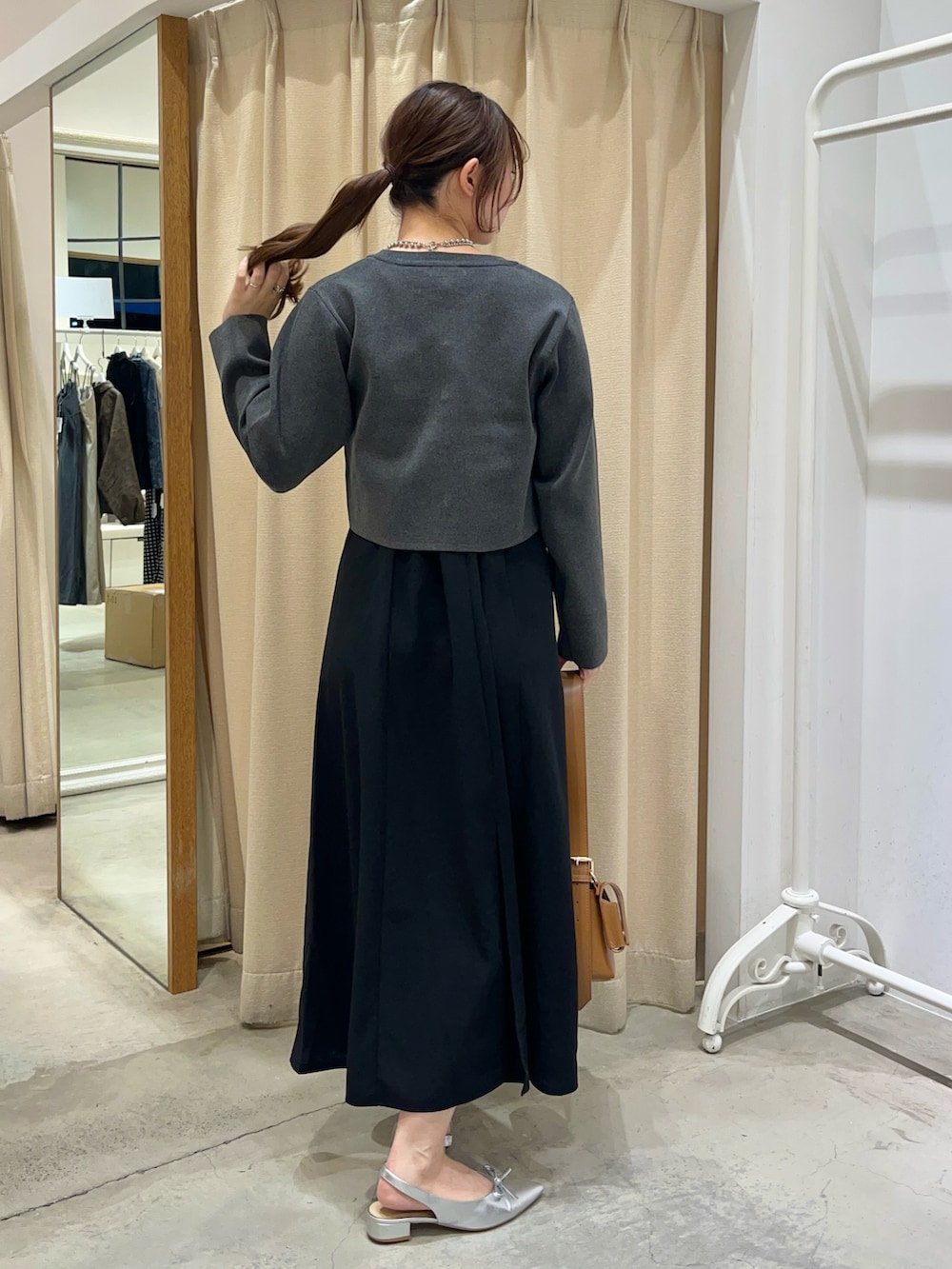 ブラック系のワンピース、グレー系のカーディガン/ボレロ、イエロー系のショルダーバッグを着用したレディースの秋コーディネートの2枚目の写真