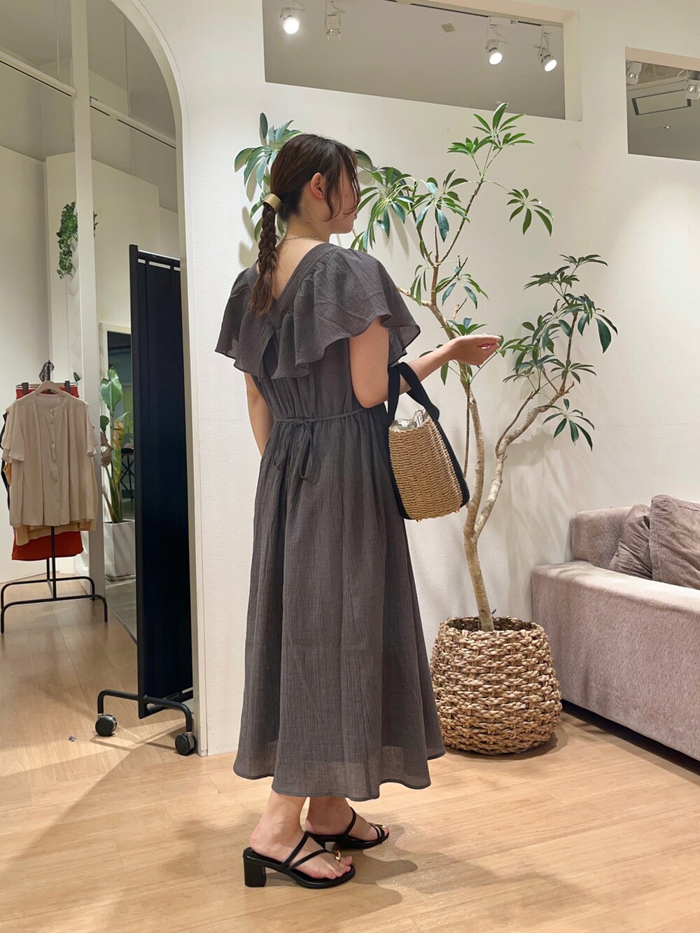 グレー系のワンピース、ブラック系のショルダーバッグを着用したレディースの夏コーディネートの2枚目の写真