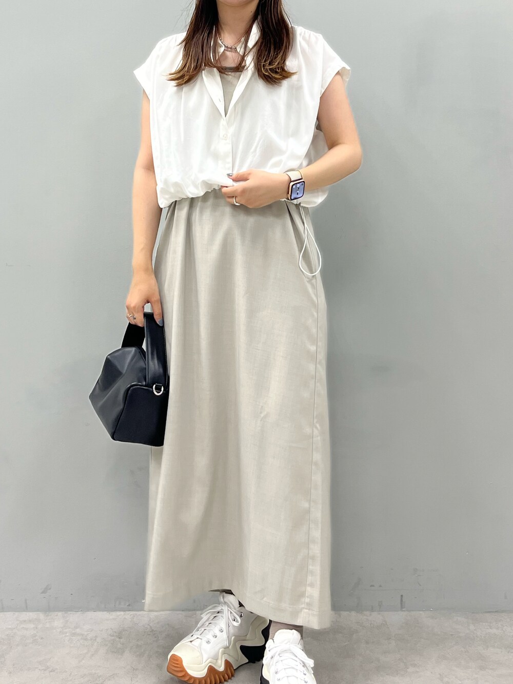 ホワイト系のワンピース、ブラウン系のショルダーバッグを着用したレディースの夏コーディネートの2枚目の写真