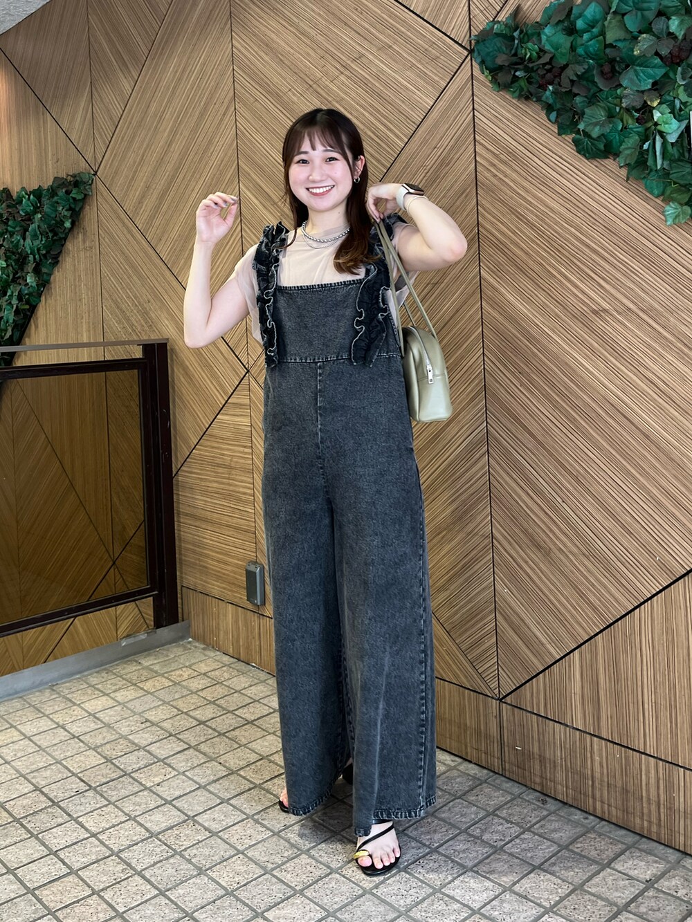 ベージュ系のニット/セーター、グレー系のサロペット/オーバーオールを着用したレディースの夏コーディネートの2枚目の写真