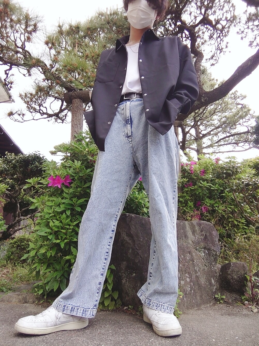 ブルー系のチノパンツ、ホワイト系のスニーカー、ブラック系のシャツ/ブラウスを着用したメンズの春コーディネートの2枚目の写真