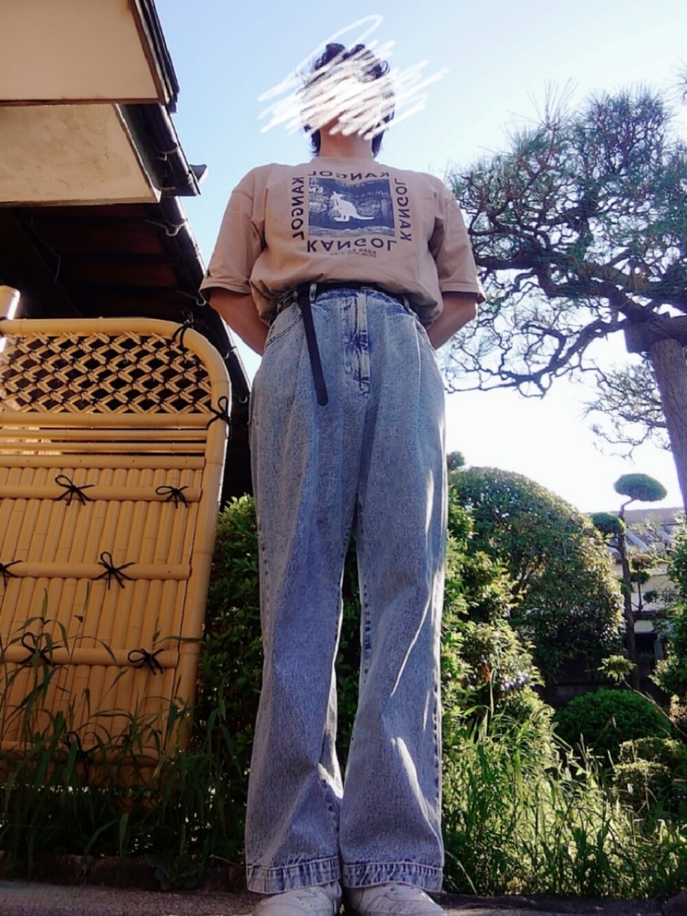 ベージュ系のTシャツ/カットソー、ブルー系のチノパンツ、ホワイト系のスニーカーを着用したメンズの秋コーディネートの2枚目の写真