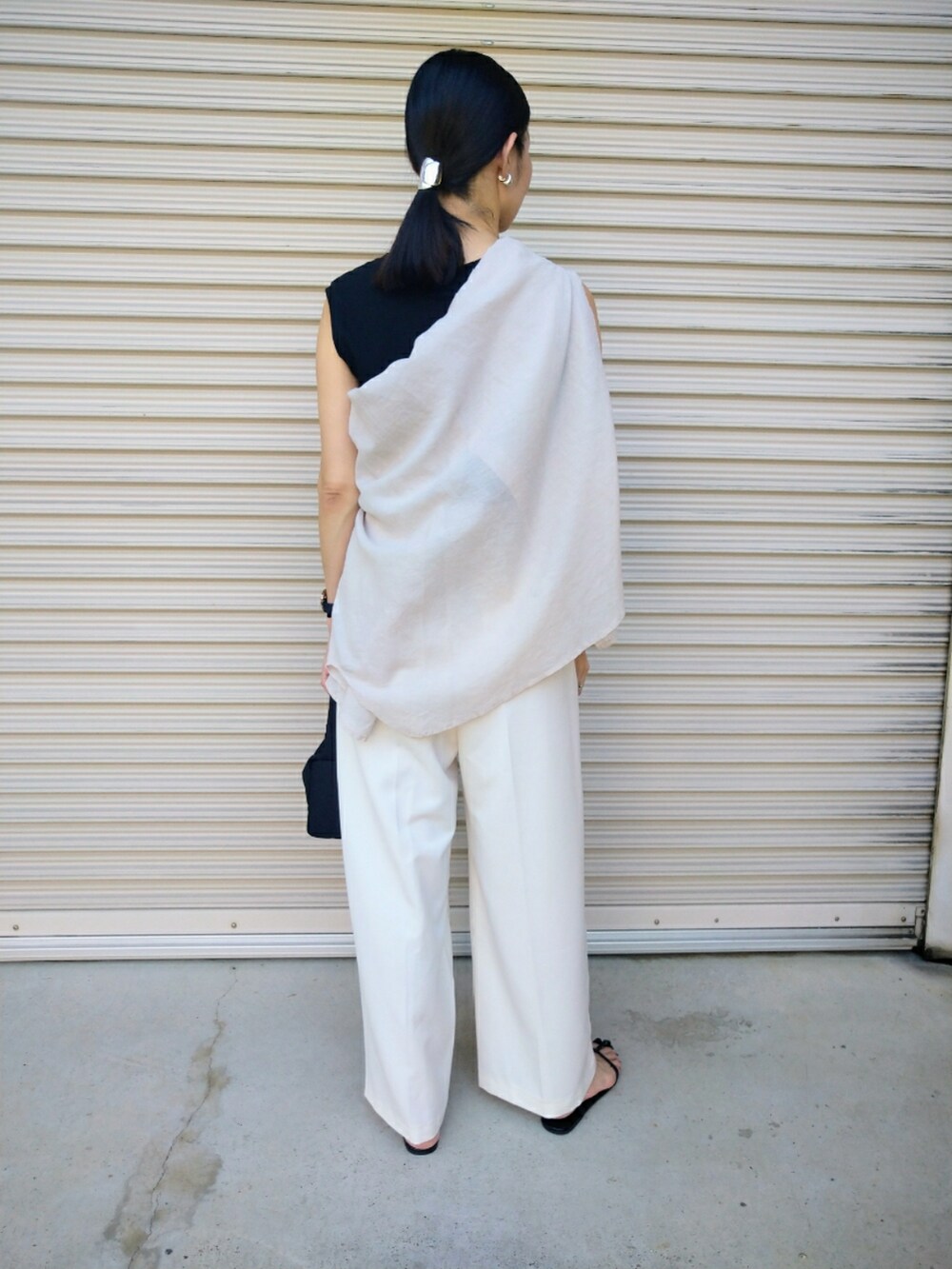 ホワイト系のシャツ/ブラウス、ホワイト系のスラックス、ブラック系のハンドバッグを着用したレディースの夏コーディネートの2枚目の写真