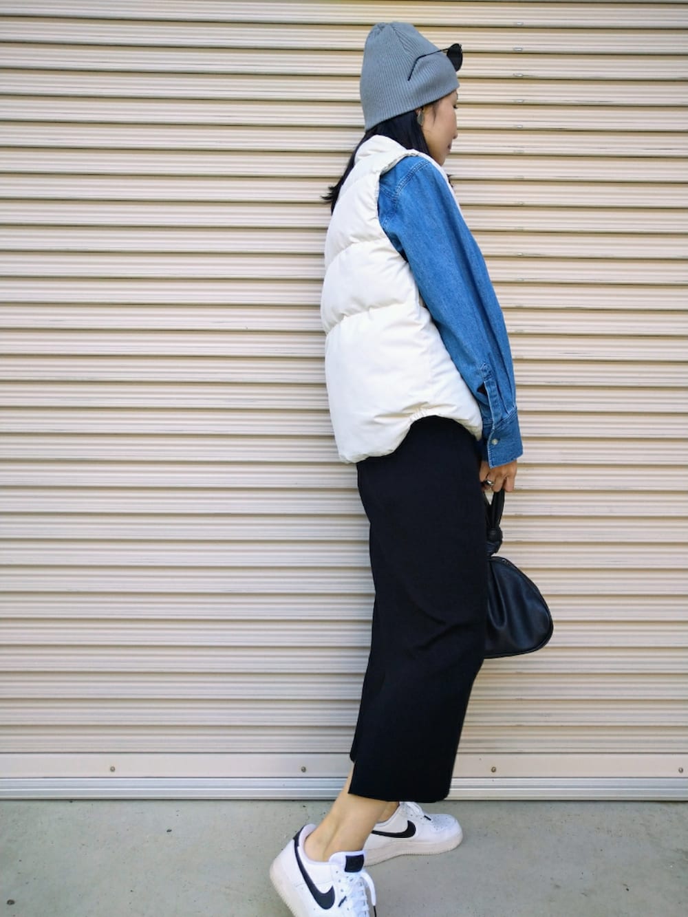 ホワイト系のベスト、ブルー系のシャツ/ブラウス、ブラック系のスカートを着用したレディースの秋コーディネートの4枚目の写真