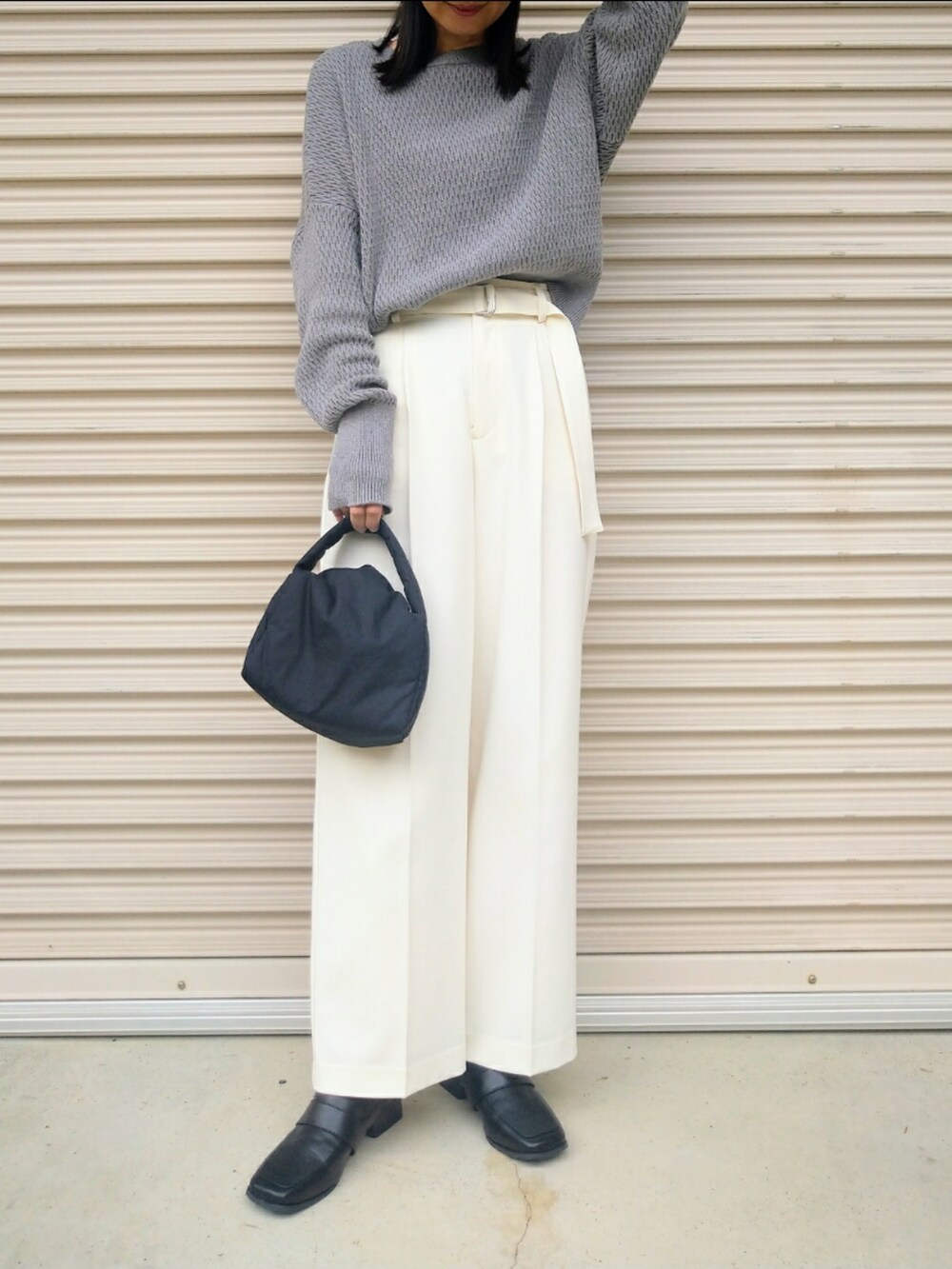 グレー系のニット/セーター、ホワイト系のその他パンツ、ブラック系のハンドバッグを着用したレディースの秋コーディネートの2枚目の写真