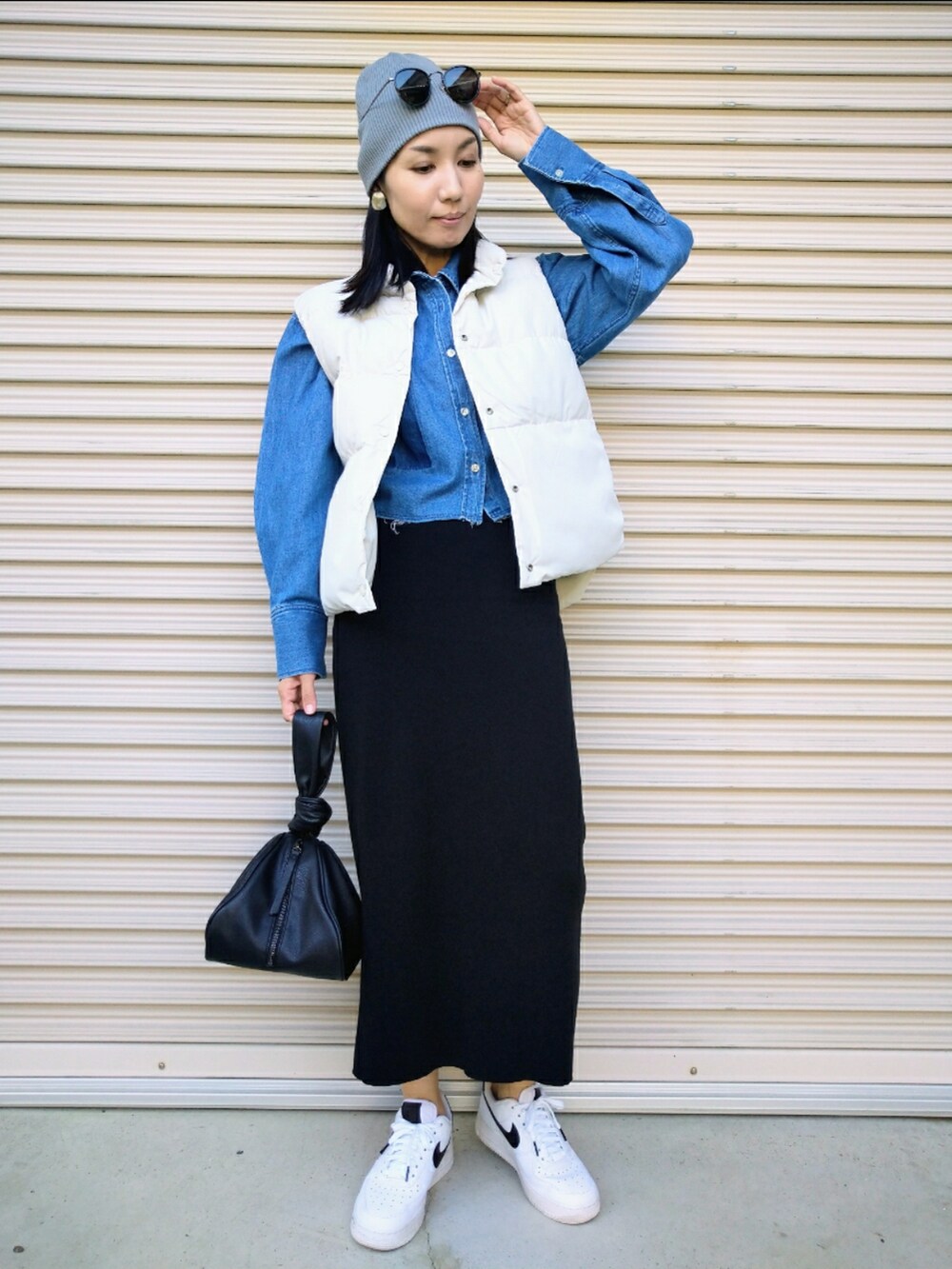 ホワイト系のベスト、ブルー系のシャツ/ブラウス、ブラック系のスカートを着用したレディースの秋コーディネートの3枚目の写真