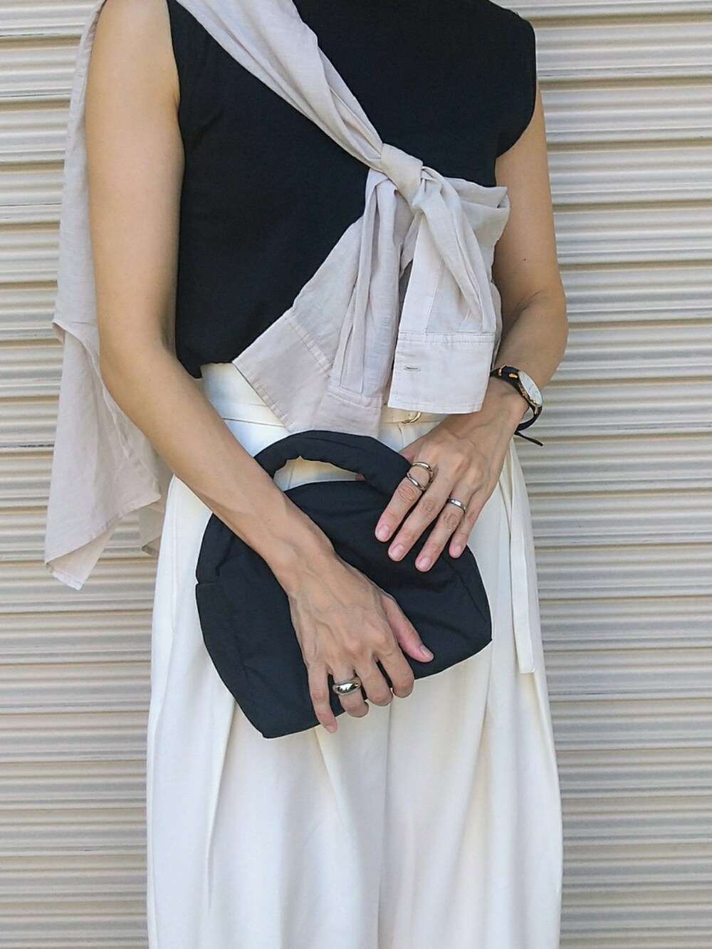 ホワイト系のシャツ/ブラウス、ホワイト系のスラックス、ブラック系のハンドバッグを着用したレディースの夏コーディネートの4枚目の写真
