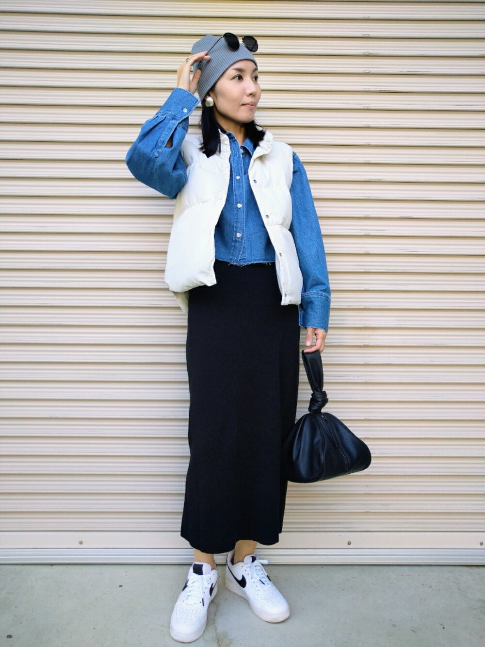 ホワイト系のベスト、ブルー系のシャツ/ブラウス、ブラック系のスカートを着用したレディースの秋コーディネートの2枚目の写真