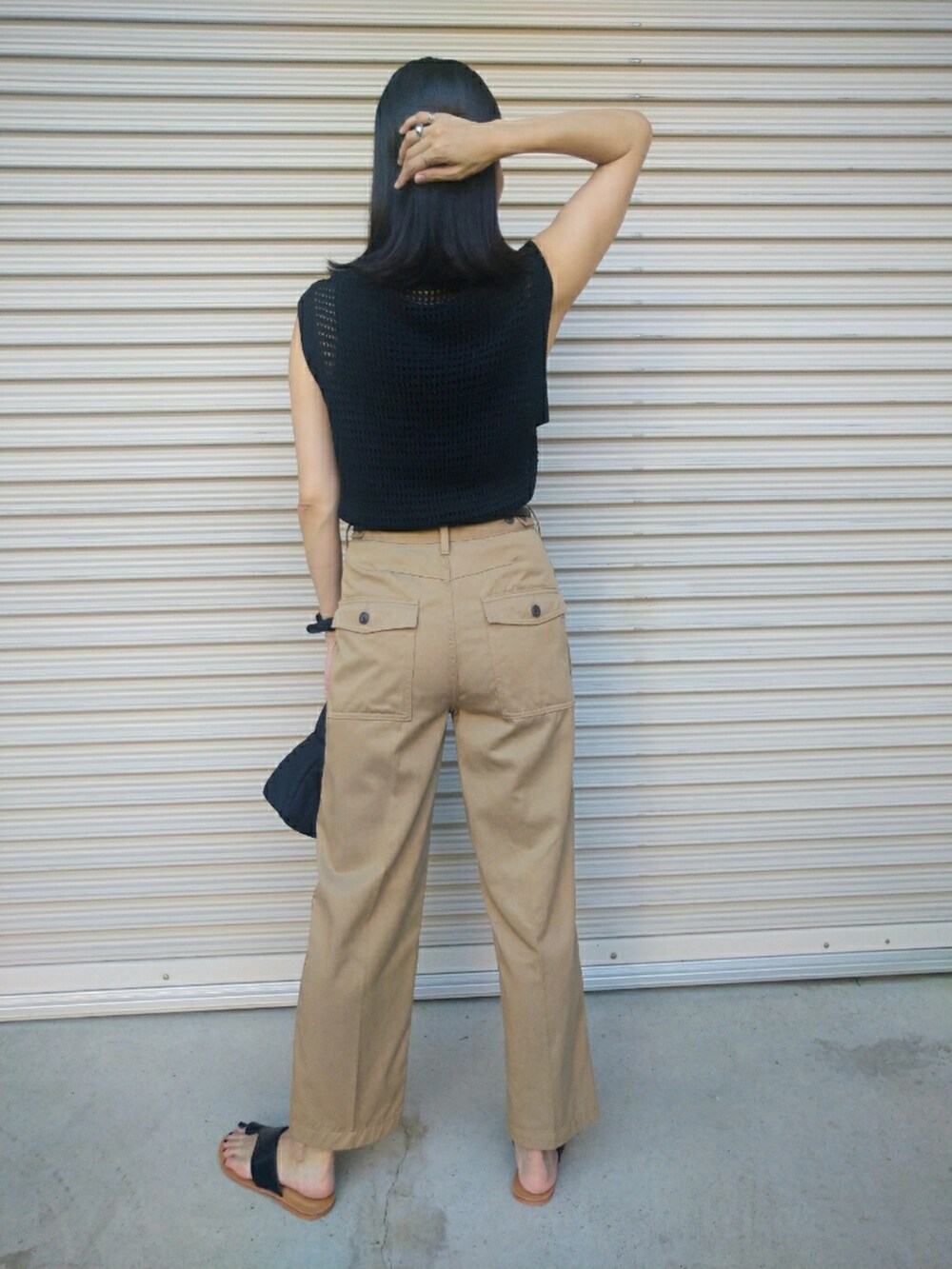 ブラック系のトップス、ベージュ系のその他パンツ、ブラック系のハンドバッグを着用したレディースの夏コーディネートの2枚目の写真