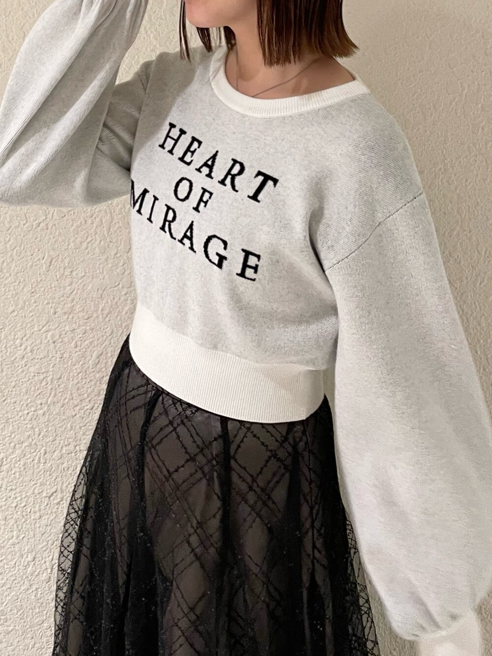 ブラック系のスカート、ホワイト系のニット/セーター、ブラック系のブーツを着用したレディースの冬コーディネートの5枚目の写真