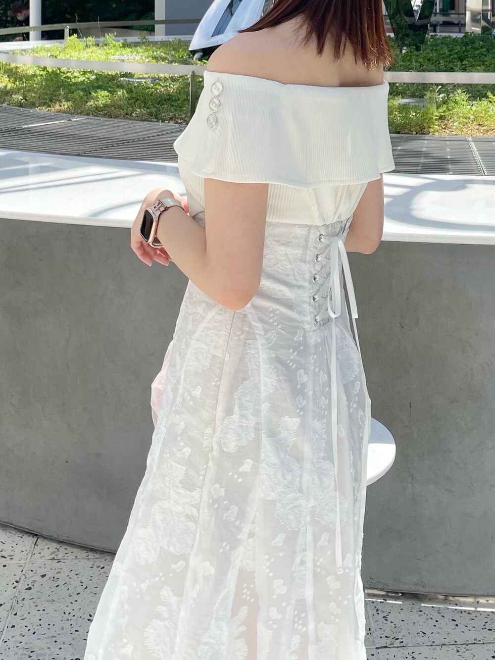 ホワイト系のワンピース、ピンク系のハンドバッグ、ホワイト系のパンプスを着用したレディースの春コーディネートの4枚目の写真