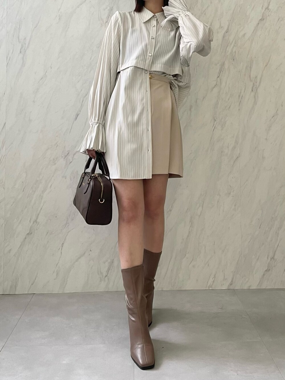 イエロー系のワンピース、ベージュ系のブーツを着用したレディースの冬コーディネートの3枚目の写真