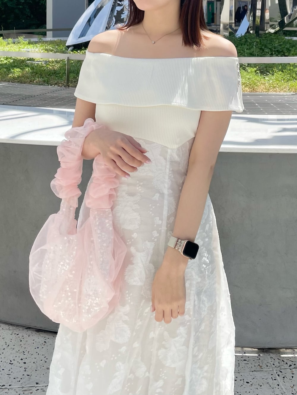 ホワイト系のワンピース、ピンク系のハンドバッグ、ホワイト系のパンプスを着用したレディースの春コーディネートの3枚目の写真