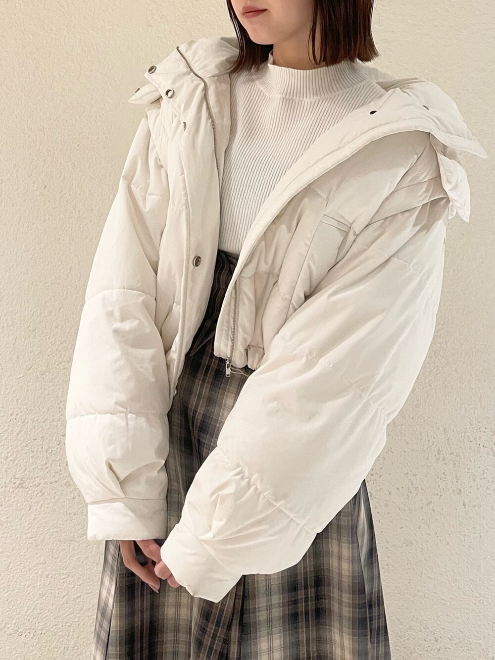 ホワイト系のニット/セーター、ホワイト系のダウンジャケット/コート、ブラウン系のスカートを着用したレディースの冬コーディネートの3枚目の写真