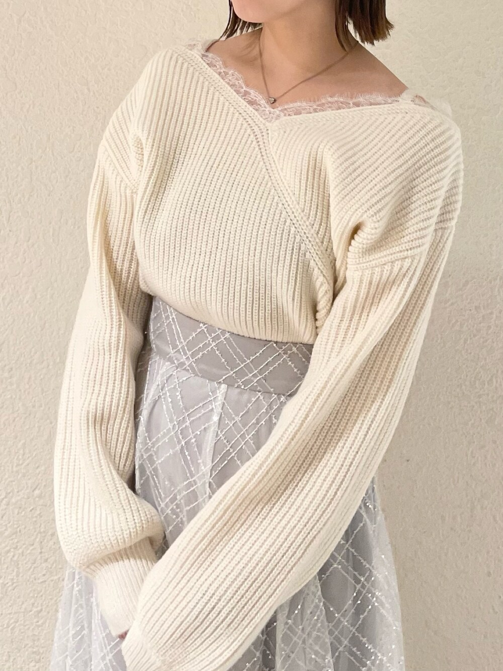 ホワイト系のニット/セーター、ホワイト系のパンプス、グレー系のスカートを着用したレディースの冬コーディネートの4枚目の写真