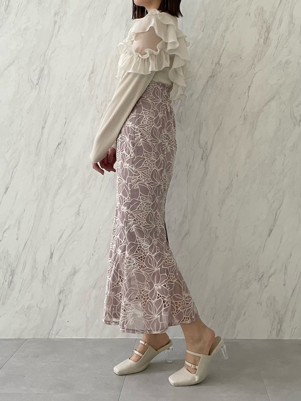 ベージュ系のTシャツ/カットソー、パープル系のスカートを着用したレディースの冬コーディネートの2枚目の写真