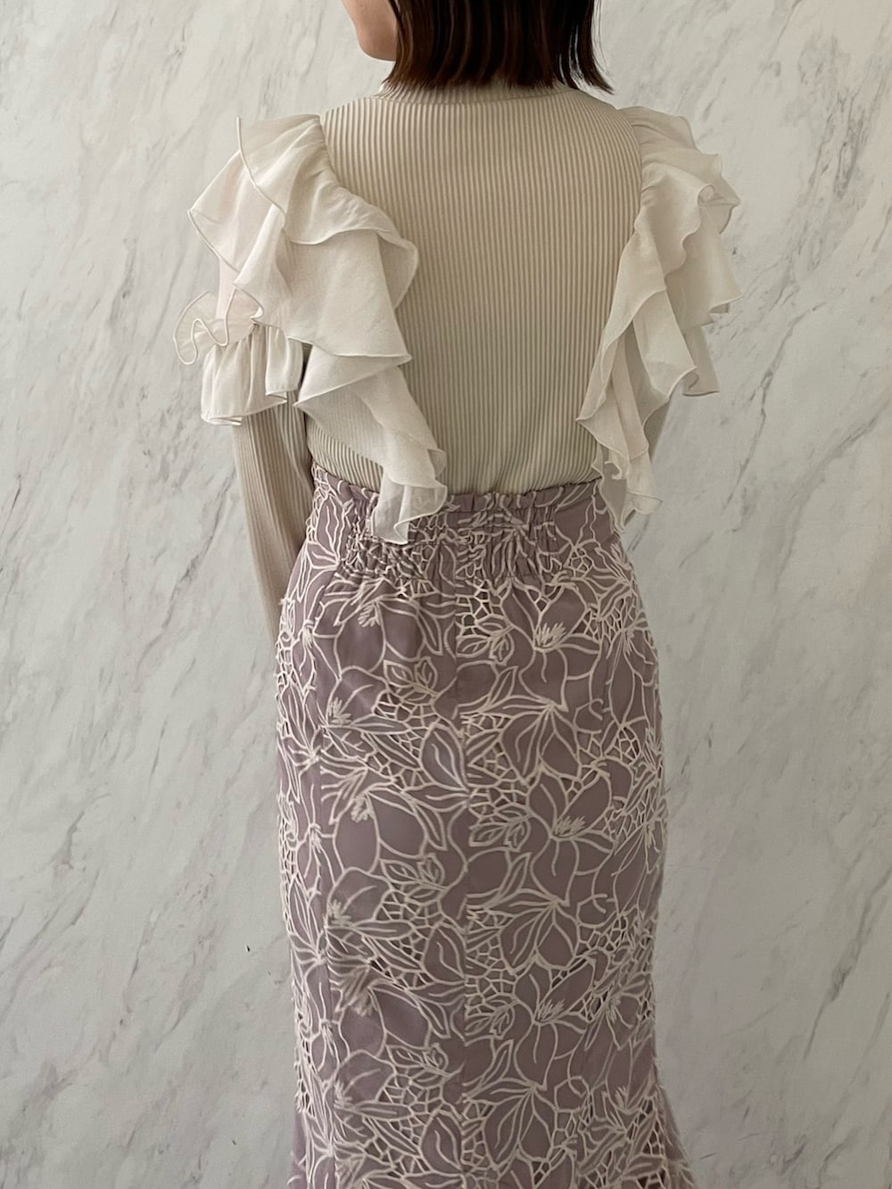 ベージュ系のTシャツ/カットソー、パープル系のスカートを着用したレディースの冬コーディネートの5枚目の写真