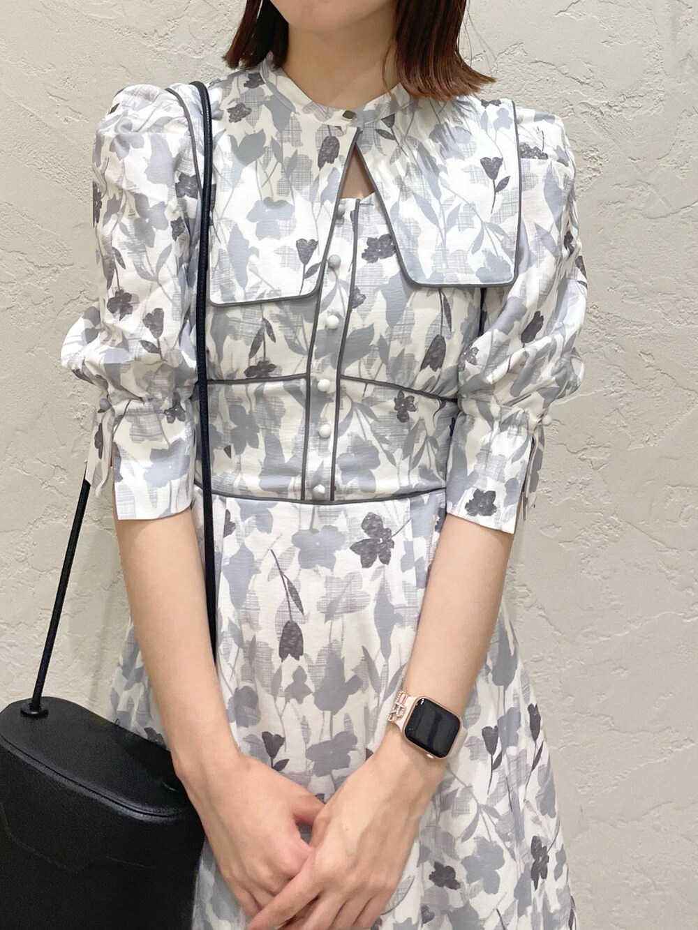 グレー系のワンピース、ブラック系のハンドバッグ、ブラック系のローファーを着用したレディースの秋コーディネートの4枚目の写真