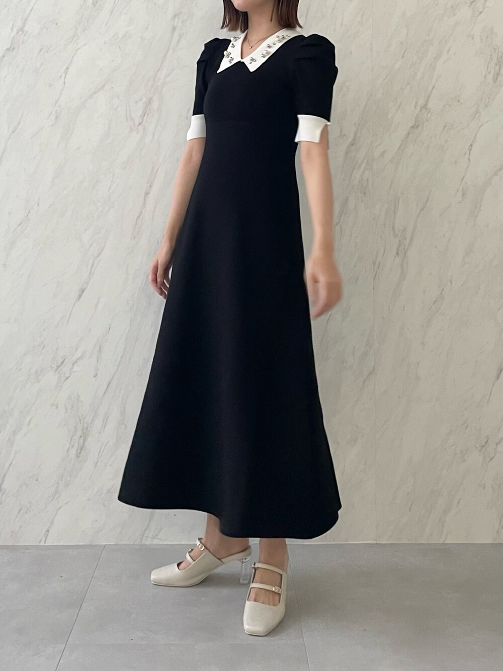 ブラック系のワンピースを着用したレディースの冬コーディネートの2枚目の写真