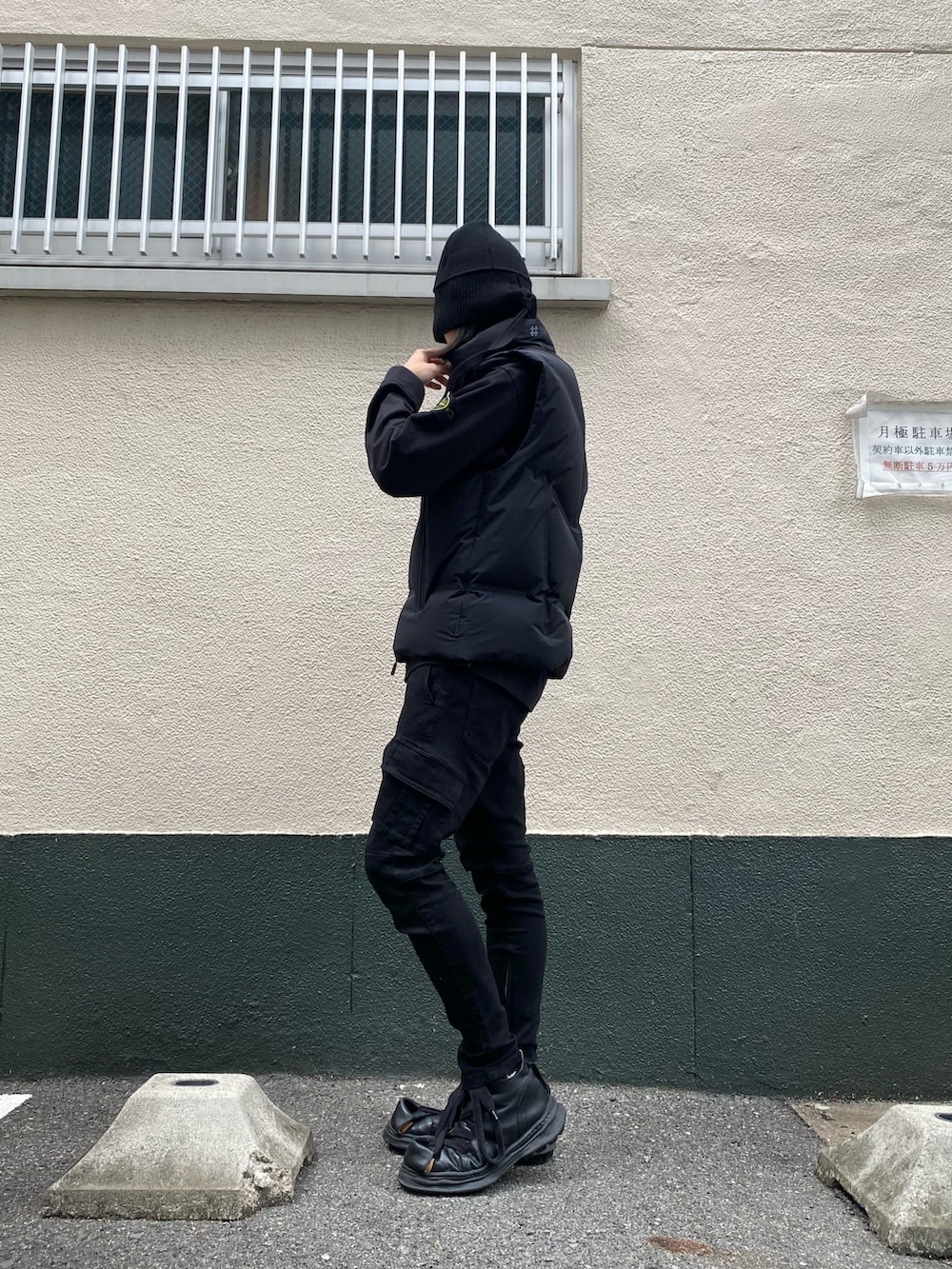 ブラック系のダウンベスト、ブラック系のカーゴパンツ、ブラック系のスウェットを着用したメンズの秋コーディネートの2枚目の写真