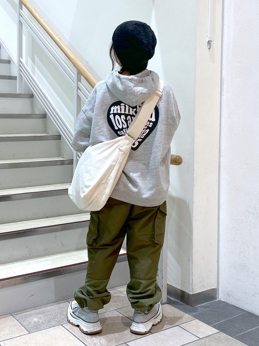 グリーン系のカーゴパンツ、ホワイト系のショルダーバッグ、その他のパーカーを着用したレディースの秋コーディネートの2枚目の写真