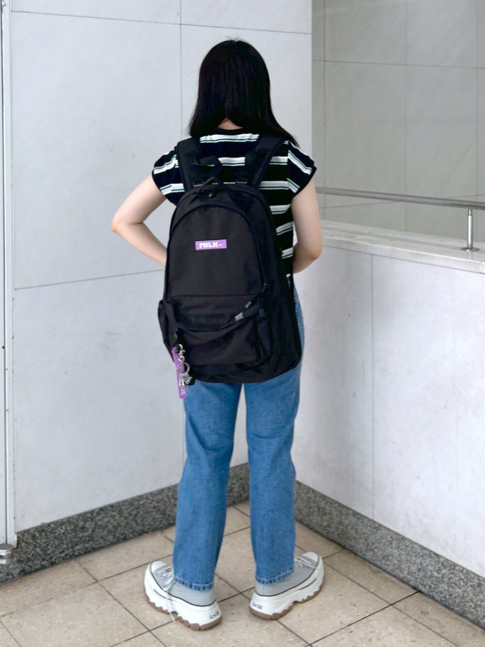ブラック系のTシャツ/カットソー、ブルー系のデニムパンツ、グレー系のスニーカーを着用したレディースの夏コーディネートの3枚目の写真