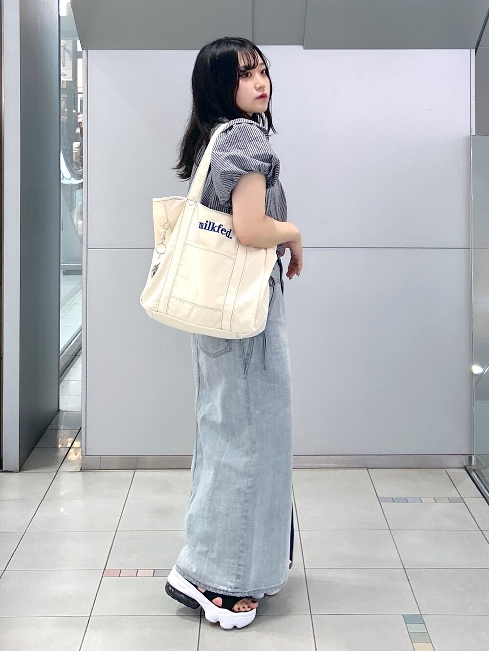 「ミルクフェド、ミルクフェド(MILKFED.)、MILKFED.、テーマパークコーデ、デニムスカート、パフスリーブ、トートバッグ、フリル、夏コーデ、休日スタイル、お出かけコーデ、初夏コーデ、ブルー、ストライプ、ootd」｜「MILKFED.のDENIM LONG SKIRT（デニムスカート、ブルー系）」を使った、レイナさん（レディース・154cm）の夏コーディネートの2枚目の写真