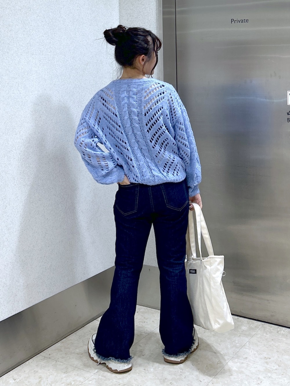 ブルー系のトートバッグ、ブルー系のニット/セーター、ブルー系のデニムパンツを着用したレディースの秋コーディネートの2枚目の写真