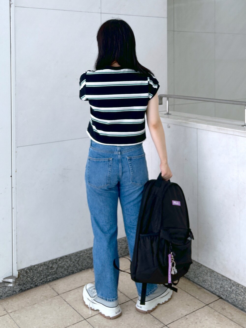 ブラック系のTシャツ/カットソー、ブルー系のデニムパンツ、グレー系のスニーカーを着用したレディースの夏コーディネートの2枚目の写真