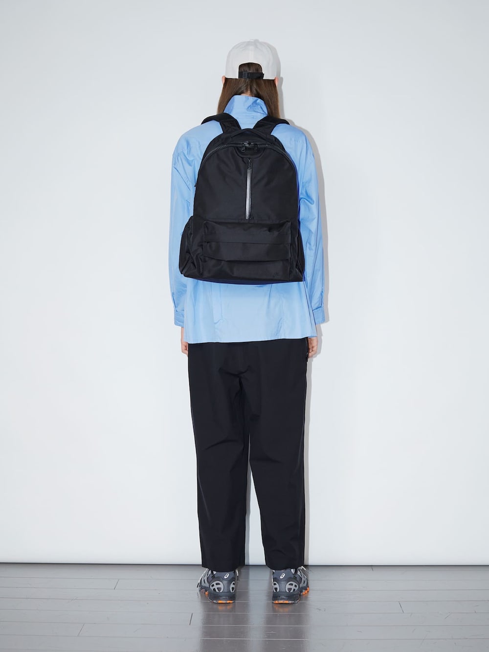 ブルー系のシャツ/ブラウス、ブラック系のバックパック/リュック、ホワイト系のキャップを着用したメンズの夏コーディネートの3枚目の写真