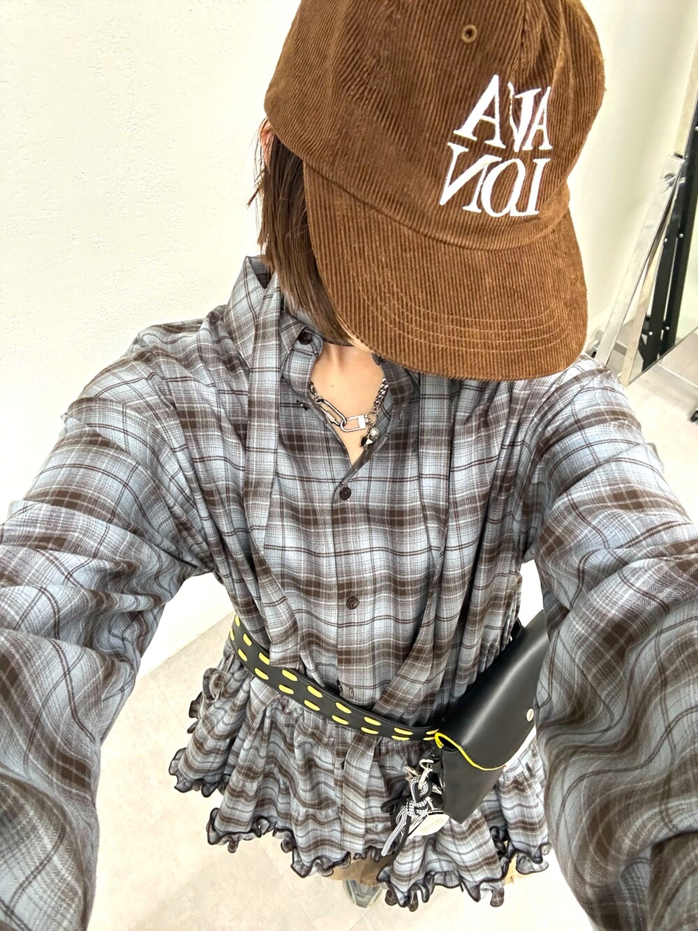 グレー系のシャツ/ブラウス、ブラウン系のデニムパンツ、ブラウン系のキャップを着用したレディースの秋コーディネートの4枚目の写真