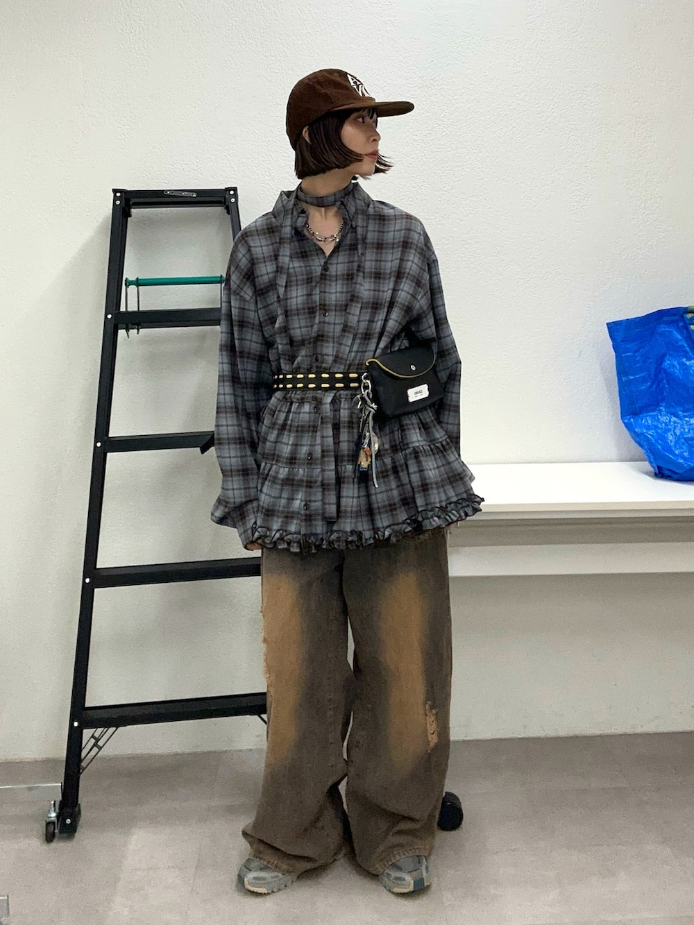 グレー系のシャツ/ブラウス、ブラウン系のデニムパンツ、ブラウン系のキャップを着用したレディースの秋コーディネートの3枚目の写真