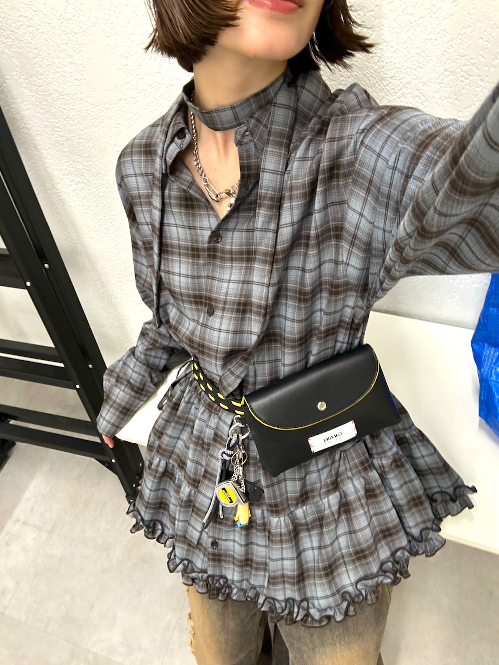 グレー系のシャツ/ブラウス、ブラウン系のデニムパンツ、ブラウン系のキャップを着用したレディースの秋コーディネートの2枚目の写真