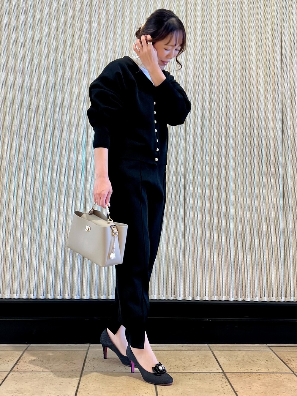 ブラック系のカーディガン/ボレロ、ベージュ系のバッグ、ブラック系のその他パンツを着用したレディースの冬コーディネートの4枚目の写真